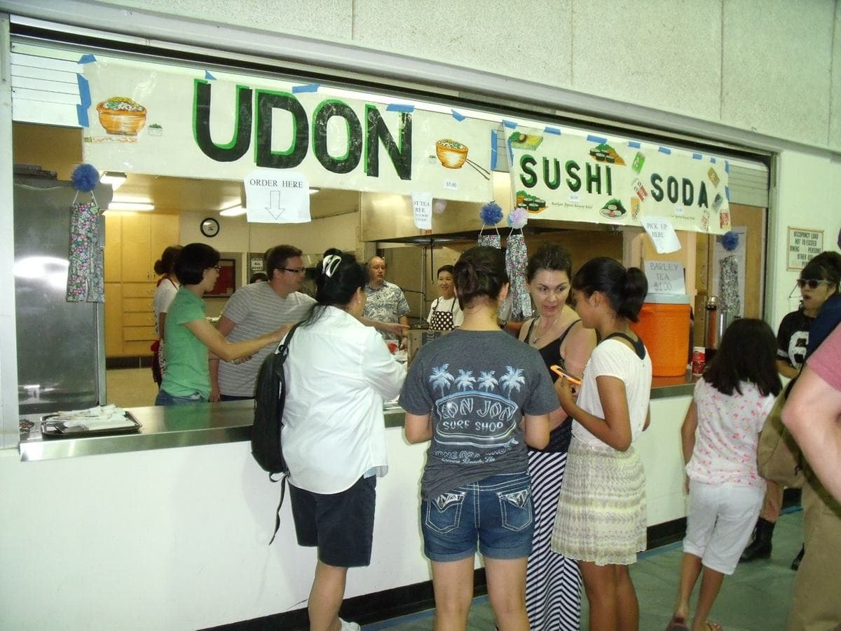 Festival-goers lining up at the udon and sushi counter