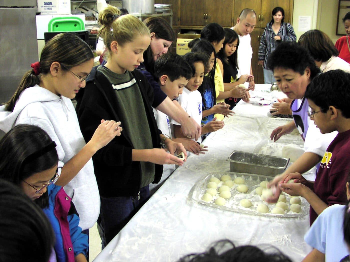 Students and families shaping mochi at the year-end mochitsuki