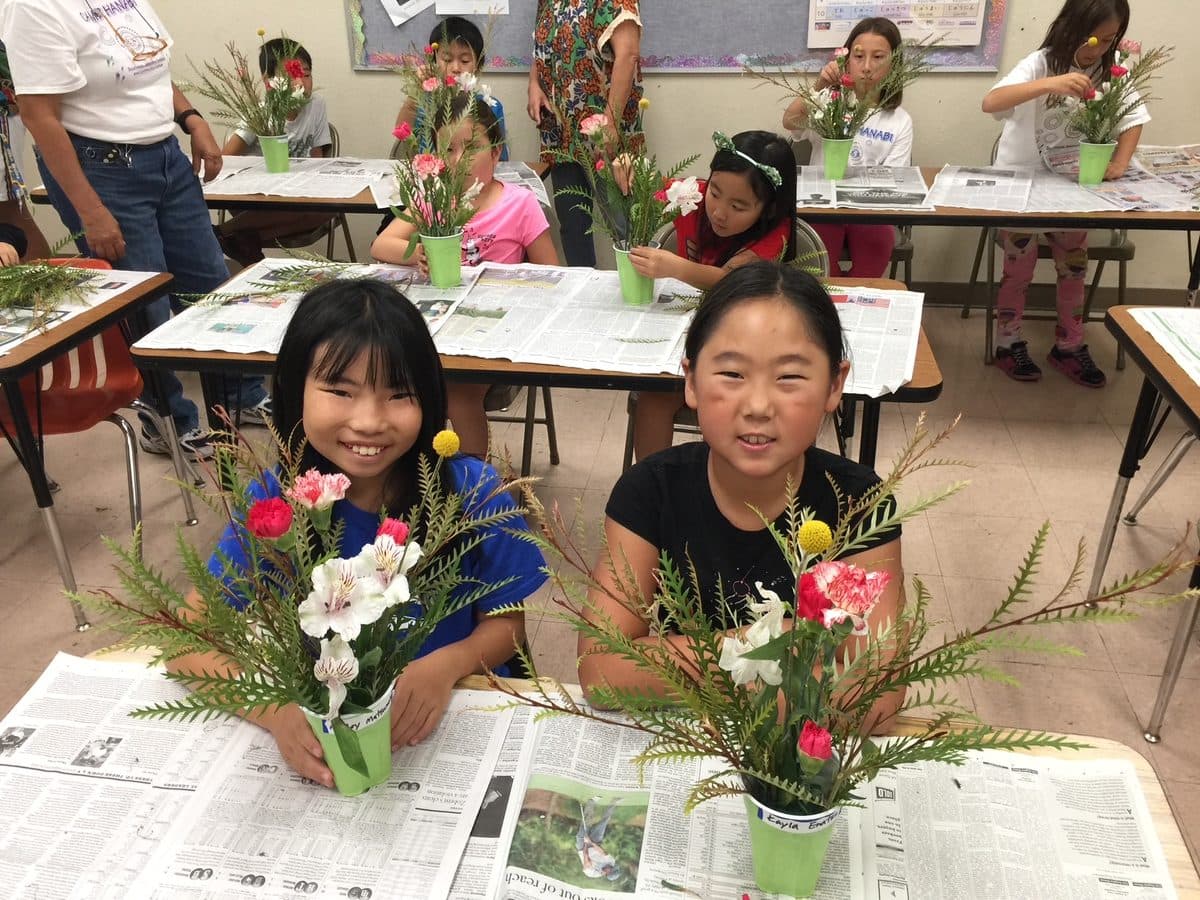 Students with the flower arrangements they made in class