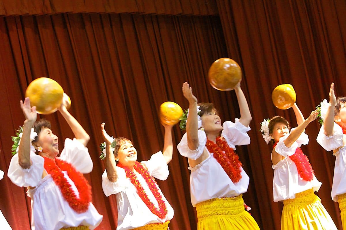 Hula dancers performing with ʻulīʻulī gourd rattles