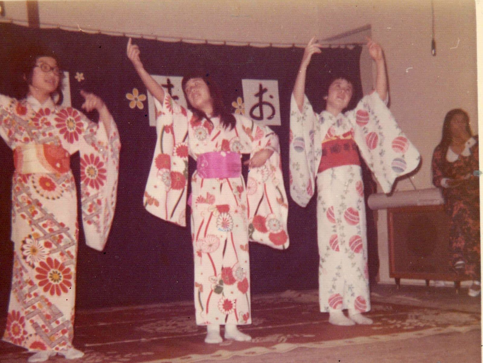 Three dancers in yukata performing on the school stage in 1972
